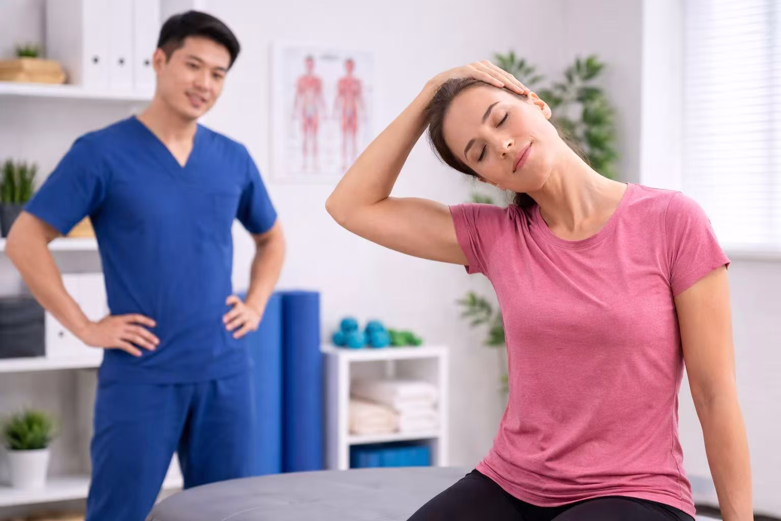 a physiotherapist oversees a patient doing stretching exercise